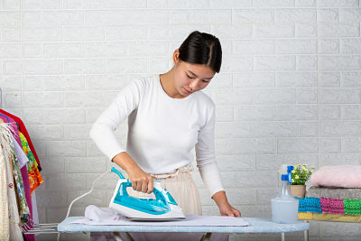 Young housewives who are using irons Ironing his clothes on a white brick background 